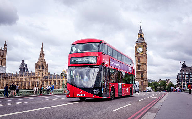 Double-decker and the Big Ben in London London, UK - July 8, 2015: Double-decker and the Big Ben in London. The bus is driving across the Westminster bridge with people walking in the background. double decker bus stock pictures, royalty-free photos & images