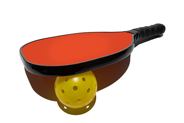 Pickleball Paddle Resting on Ball Simple isolated image of a pickleball paddle resting on ball with a white background. table tennis bat stock pictures, royalty-free photos & images