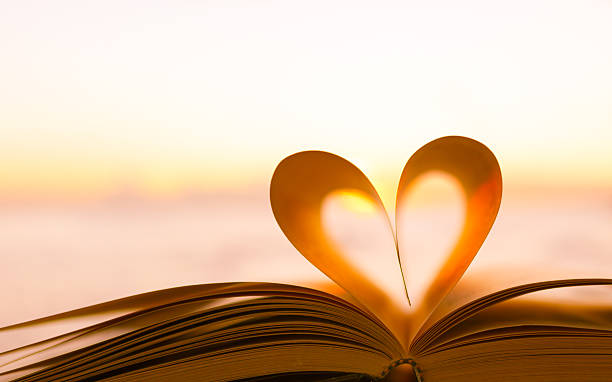 Book heart Heart from a book page against a beautiful sunset. poetry literature photos stock pictures, royalty-free photos & images