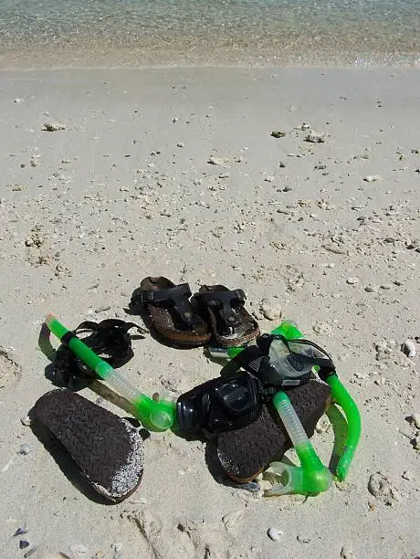 Swimming equipment laid on the whites sands.