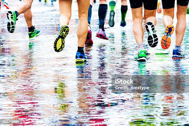 Menschen Laufen In Einen Marathon Auf Einem Wetted Oberfläche Stockfoto und mehr Bilder von Rennen - Körperliche Aktivität