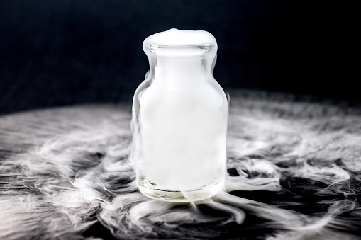 White smoke inside glass bottle at black background, Mistery hal