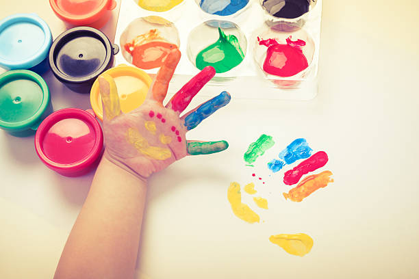 istock Child paint her palm with smiling face various colors. 503718090