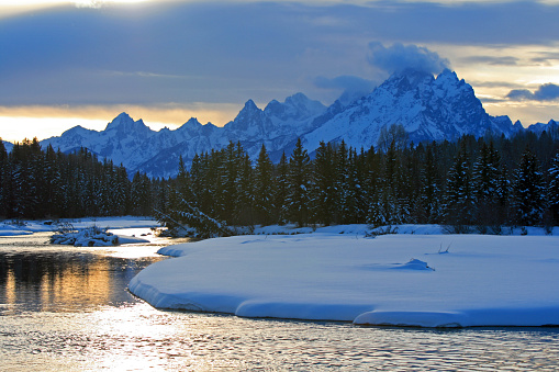 Snake River at sunset / twilight / evening below the Grand Teton mountain range peaks in the Central Rocky mountains in Grand Tetons National Park in Wyoming USA near the town of Jackson during the winter of January 2012