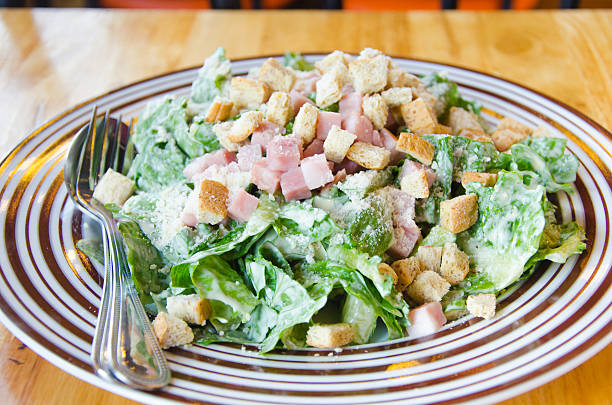 istock Caesar salad with becon and greens on wooden table 503727437