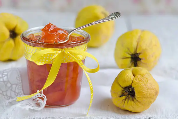 Homemade jam from a quince on a wooden table