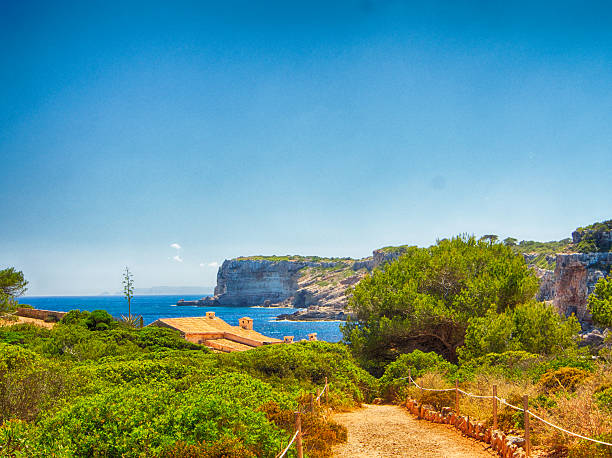 In this picture you can see a wave over the coast rocks with a blue see in the background