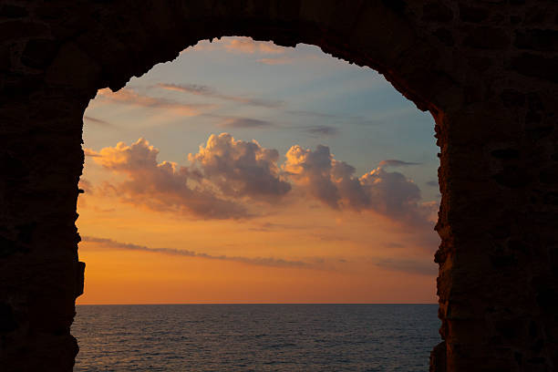 Stone arch, Mediterranean sea and evening sky Stone arch, Mediterranean sea and evening sky cefalu stock pictures, royalty-free photos & images