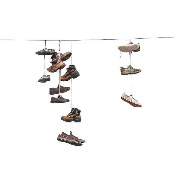 istock Old worn boots or shoes hang on a cable 503732185