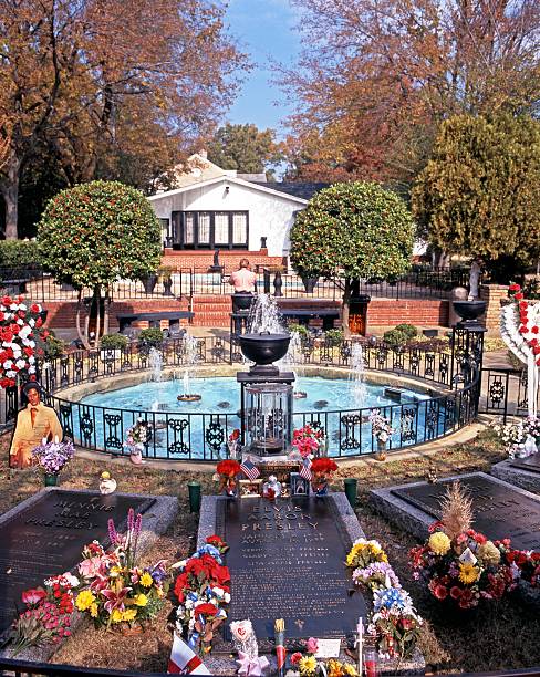 Memphis, United States - November 21, 1995: Elvis Presleys grave in the remembrance garden at Graceland with tourists enjoying the sights, the home of Elvis Presley, Memphis, Tennessee, United States of America.