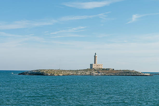 istock Old lighthouse on small island surrounded by blue sea 503733814