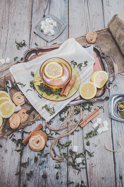istock Dried mint tea with lemon and cookies on wooden table 503734402