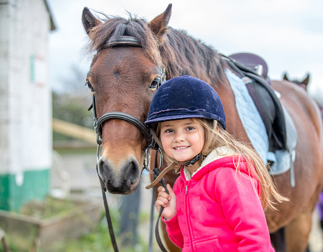Young caucasian girl enjoying horse riding lesson