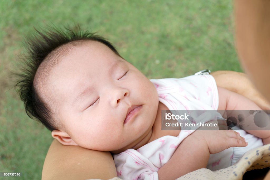 Infant sleeping Close up of infant sleeping on mother's hand Asian and Indian Ethnicities Stock Photo