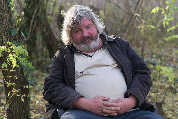 portly drunken man sad and portly drunken homeless man sitting on the chair alcoholism alcohol addiction drunk stock pictures, royalty-free photos & images