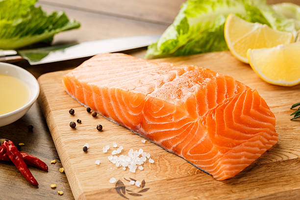 salmão peixe na tábua de corte - alaskan salmon imagens e fotografias de stock