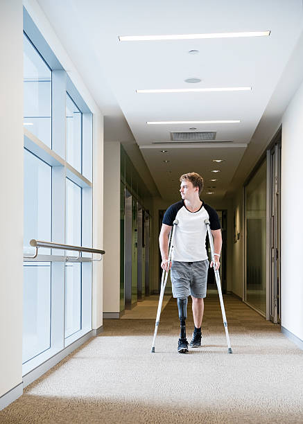 istock Male amputee walking down corridor on crutches 503744076