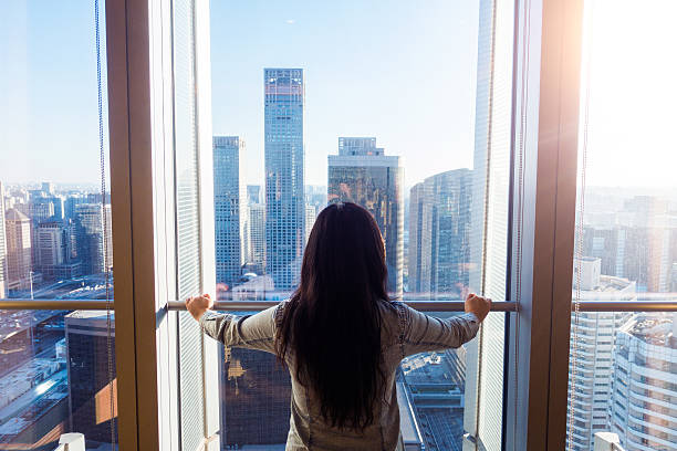 istock Woman looking cityscape through window 503744372