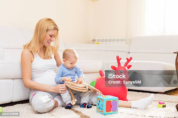 Curious Boy Playing With His Pregnant Mother Stock Photo - Download Image Now - 12-23 Months, Adult, Affectionate