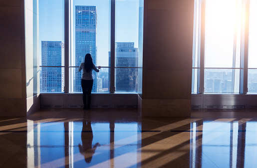Businesswoman looking cityscape in a modern business building