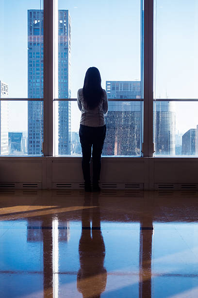 istock Young woman looking through the window 503752234