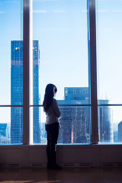 istock Young woman looking through the window 503752550