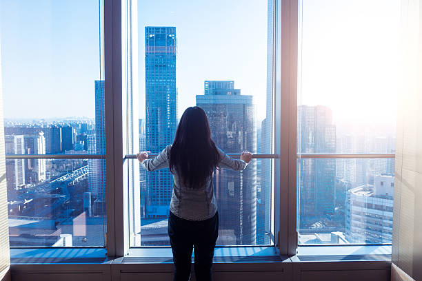 istock Woman looking cityscape through window 503752944