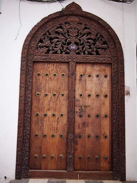 tradicional árabe puerta de madera con arco curvo en zanzíbar - door townhouse closed outdoors fotografías e imágenes de stock