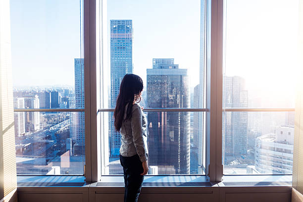 istock Woman looking cityscape through window 503753110