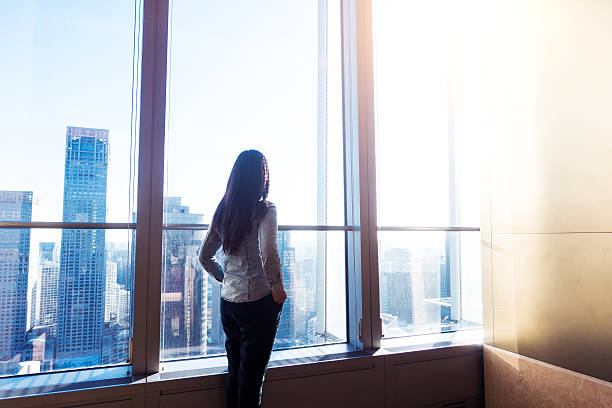 istock Woman looking cityscape through window 503753202