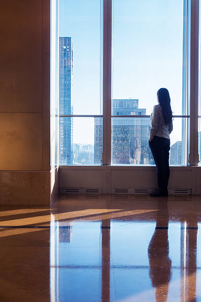 istock Woman looking cityscape through window 503753802
