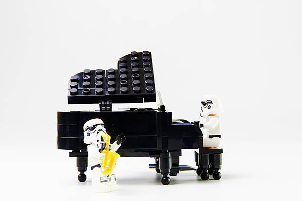 звездные войны фильм: stomtrooper играет на пианино и саксофон - lego toy close up characters стоковые фото и изображения
