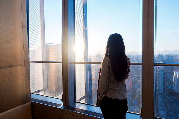 istock Woman looking cityscape through the window 503757546