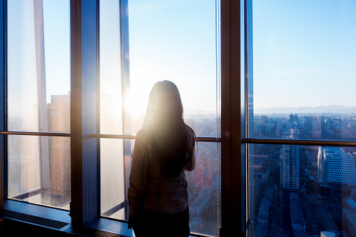 Woman looking cityscape through the window