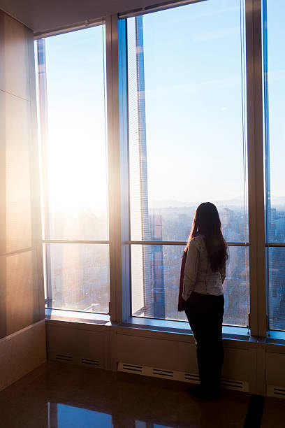 istock Woman looking cityscape through the window 503758444