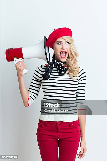 Blonde French Woman Wearing Red Beret Holding A Megaphone Stock Photo - Download Image Now
