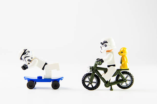 звездные войны фильм: stomtrooper езды на велосипеде и скейтбординга - lego toy close up characters стоковые фото и изображения