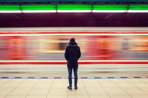 Hombre en la Estación de Metro y tren en movimiento photo