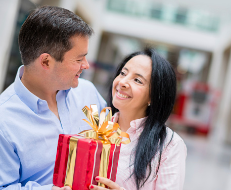 Romantic couple with a present looking very happy