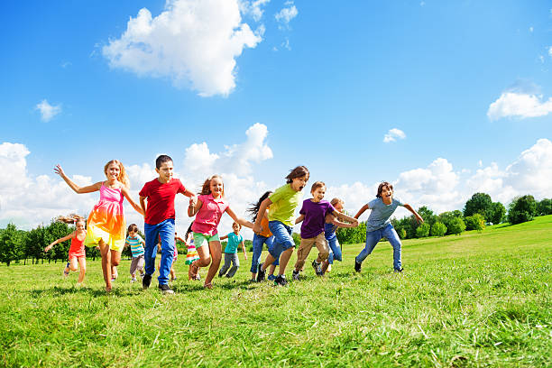 Young girls running and having fun together outdoors in the countryside at sunset