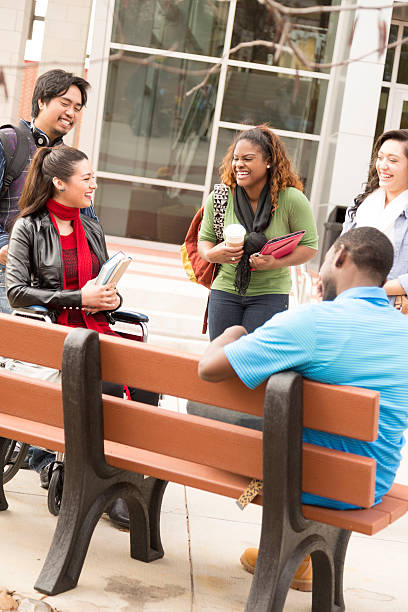 istock Education: Multi-ethnic college students talk on campus. One in wheelchair. 503782951