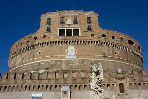 Rome, Italy - December 31, 2014: Architectural close up of Castel Sant'Angelo frontal Facade in Rome, Italy, with an angel statue in the foreground