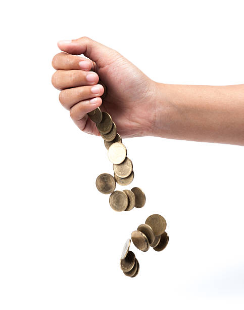 istock Hand and falling coins isolated on white background 503784449