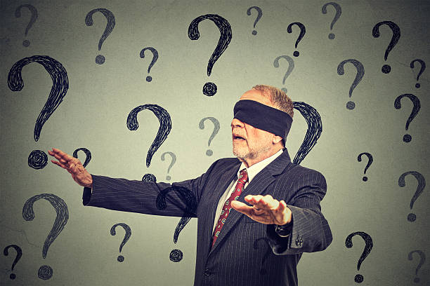 blindfolded business man walking through many questions Portrait business man blindfolded stretching his arms out walking through many questions isolated on gray wall background ignorance stock pictures, royalty-free photos & images