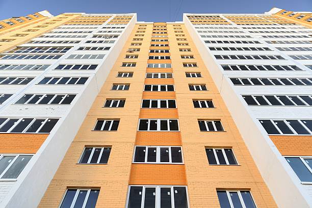 istock New building apartments painted orange on clear blue sky 503786168