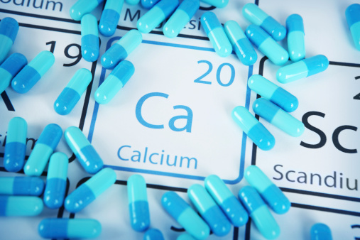 Calcium with capsules or pills on the periodic table (Periodic table made by me)  Stock image representing mineral supplementation.