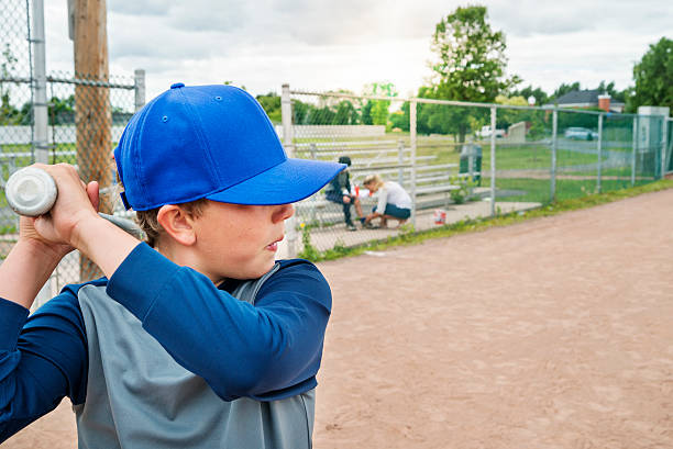 istock Boy playing baseball, mom giving first aid in background. 503787997