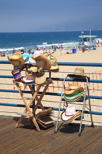 Santa Monica, California, USA - July 1, 2012: A display selling beach hats on the Santa Monica Pier in California. The pier opened in 1909 and now has an aquarium and a carousel.
