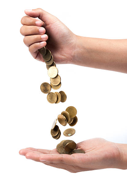 istock hand pour down coins into hands of another person. 503802097