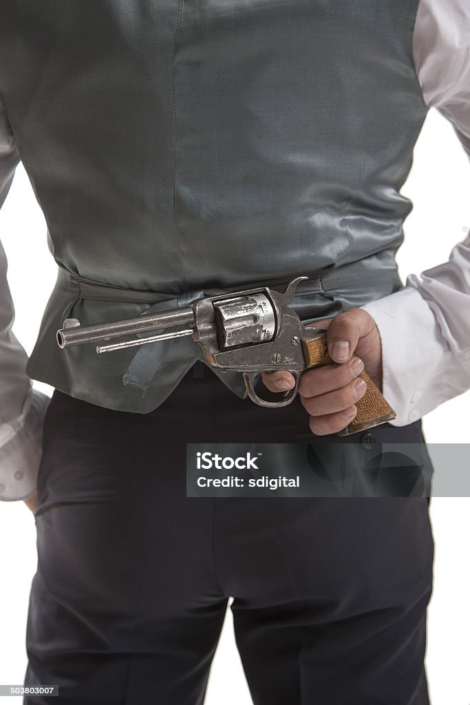 Homme tenant un pistolet derrière son dos - Photo de A la mode libre de droits